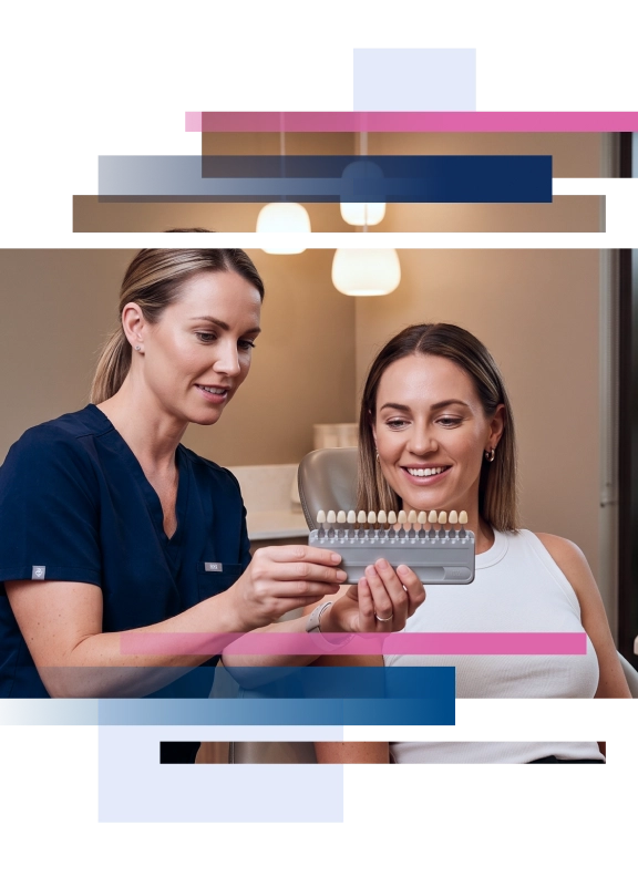 Dental professional showing a shade guide to a smiling female patient in a clinic setting.
