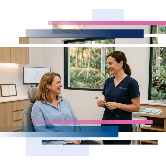 Dentist chatting with a patient in a modern dental office, both smiling, with dental tools and plants visible.