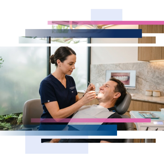 Dentist examining a patient seated in a dental chair with modern equipment in a well-lit clinic environment.