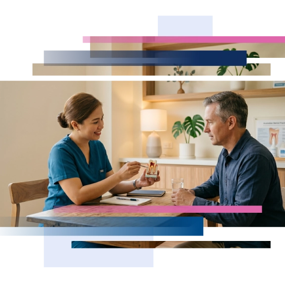 Dentist explaining a tooth model demonstrating a root canal procedure to a patient in a cozy office setting.
